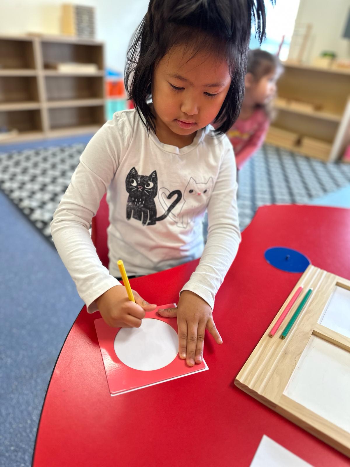 A girl drawing a circle using Montessori methods.